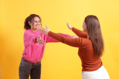 Photo of Friends welcoming each other on orange background