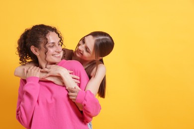 Photo of Friends hugging each other on orange background, space for text