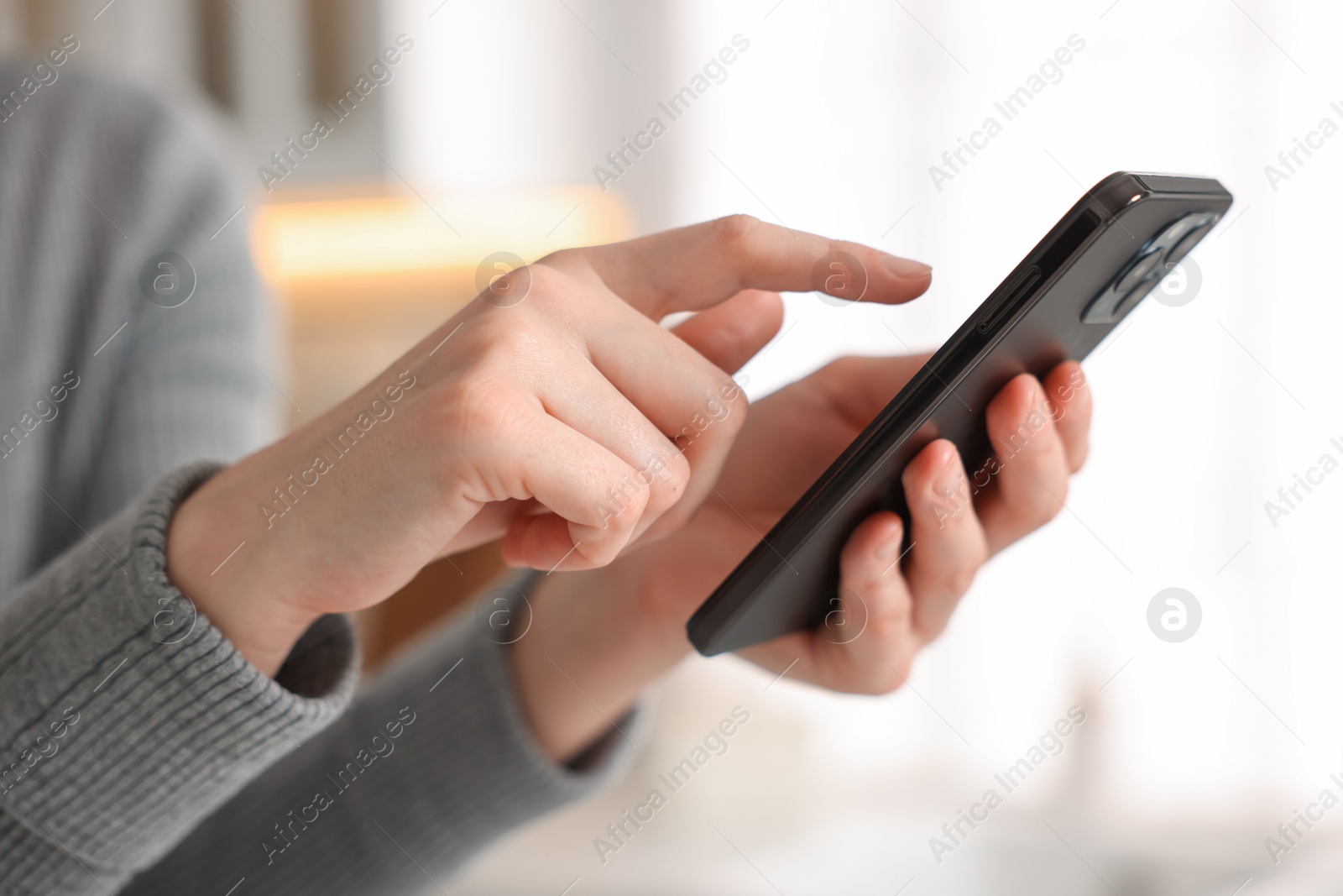 Woman using modern smartphone at home, closeup Photo of Woman using modern smartphone at home, closeup