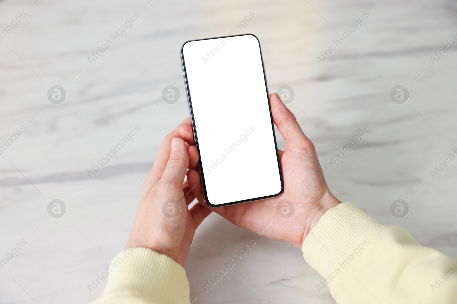 Woman using modern smartphone at white marble table, closeup Photo of Woman using modern smartphone at white marble table, closeup