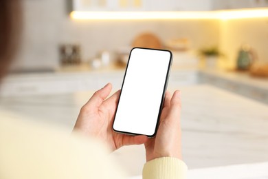 Photo of Woman using smartphone at table indoors, closeup