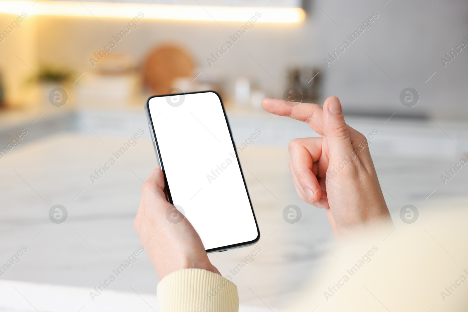 Woman using smartphone at table indoors, closeup Photo of Woman using smartphone at table indoors, closeup