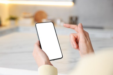 Photo of Woman using smartphone at table indoors, closeup