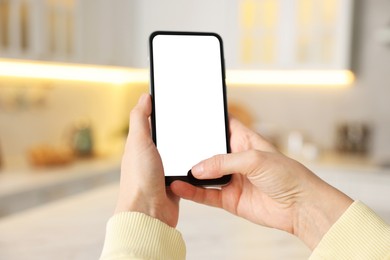 Photo of Woman using modern smartphone at home, closeup