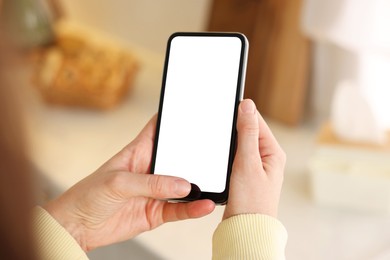 Photo of Woman using modern smartphone at home, closeup