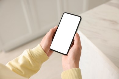 Photo of Woman using modern smartphone at home, above view