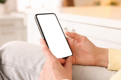 Photo of Woman using modern smartphone at home, closeup