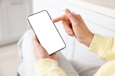 Photo of Woman using modern smartphone at home, closeup