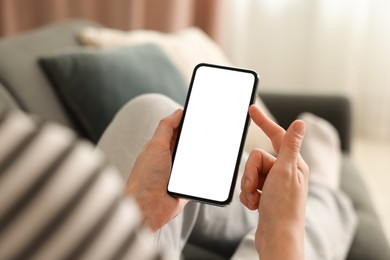 Photo of Woman using modern smartphone on sofa at home, closeup