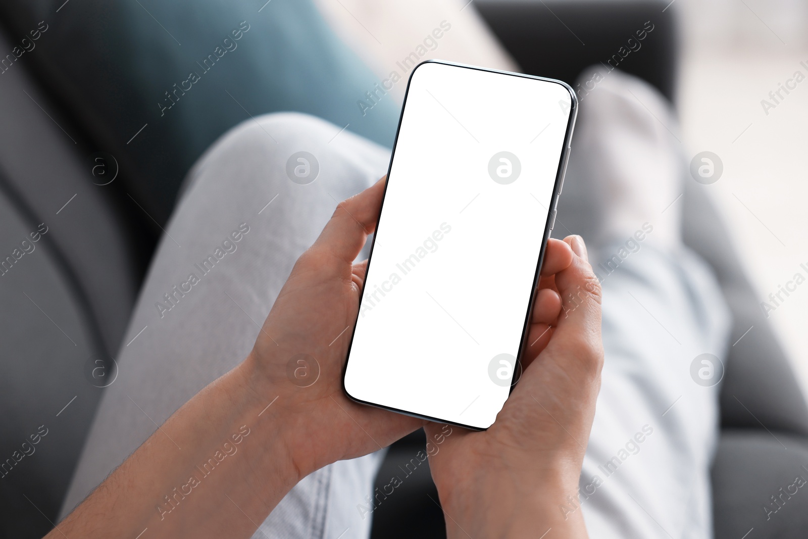 Woman using modern smartphone on sofa at home, closeup Photo of Woman using modern smartphone on sofa at home, closeup