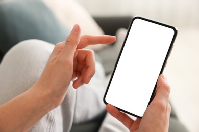 Photo of Woman using modern smartphone on sofa at home, closeup