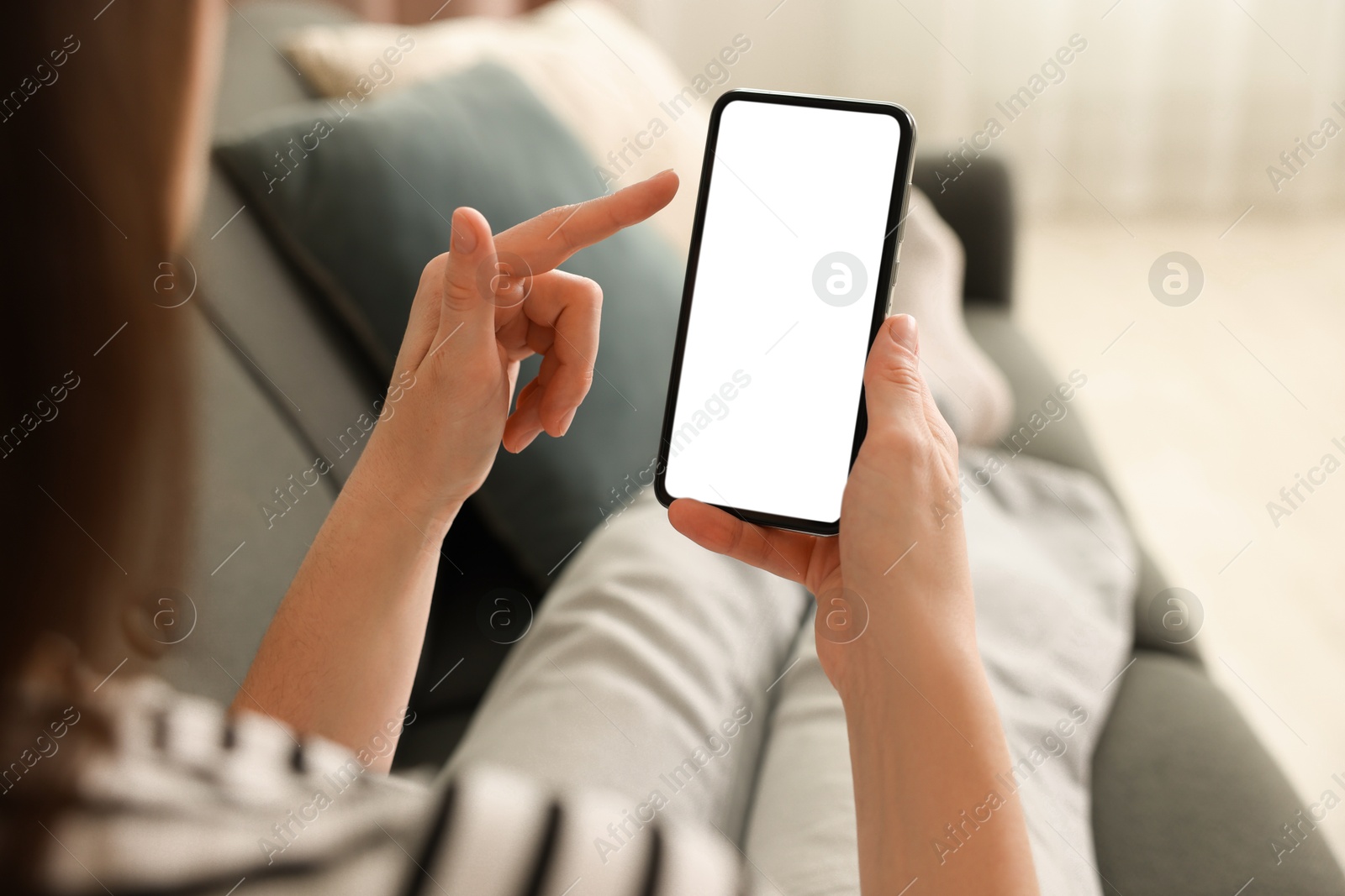 Woman using modern smartphone on sofa at home, closeup Photo of Woman using modern smartphone on sofa at home, closeup