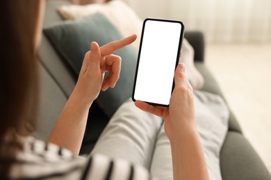 Photo of Woman using modern smartphone on sofa at home, closeup