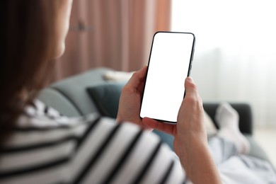 Photo of Woman using modern smartphone on sofa at home, closeup