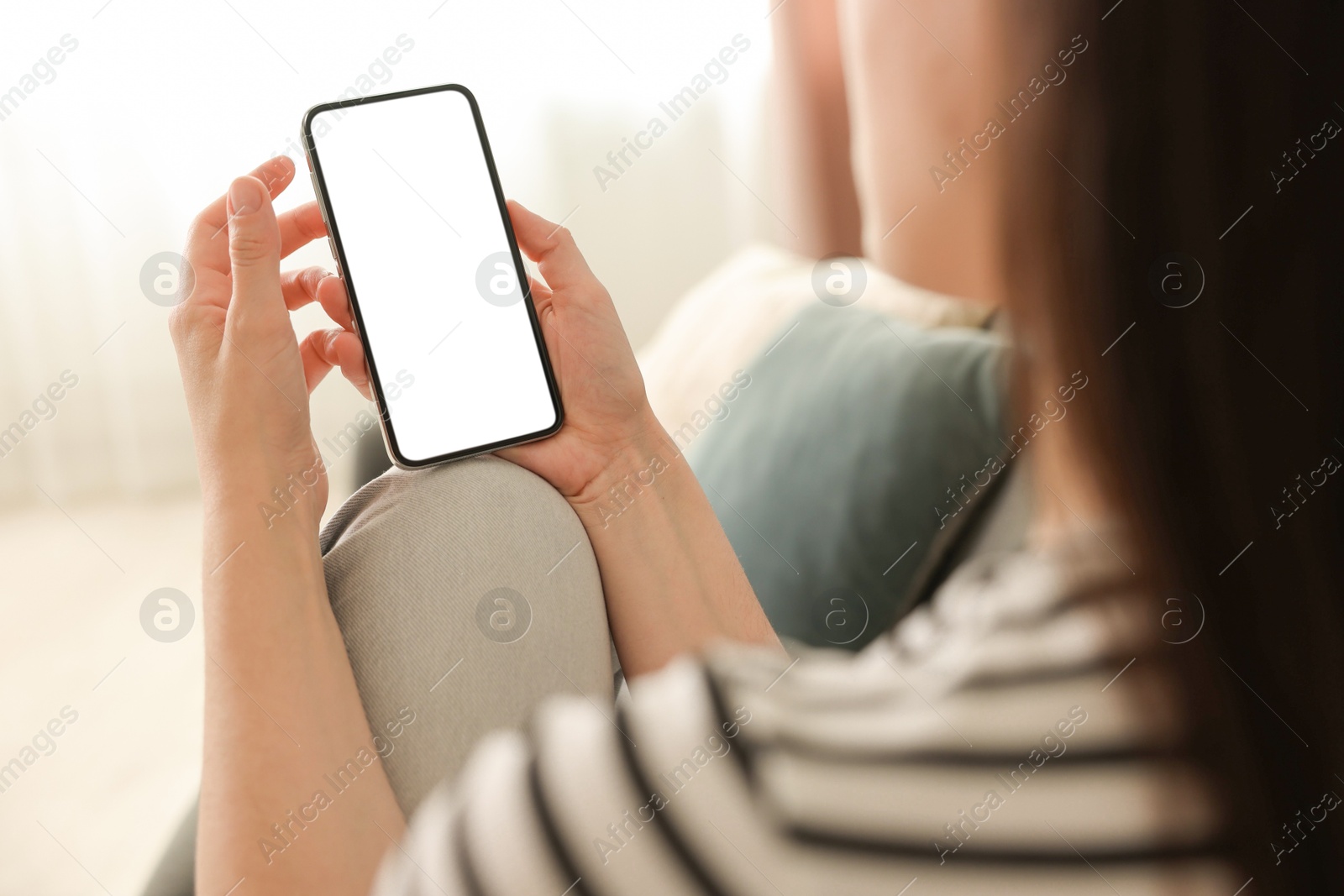 Woman using modern smartphone on sofa at home, closeup Photo of Woman using modern smartphone on sofa at home, closeup
