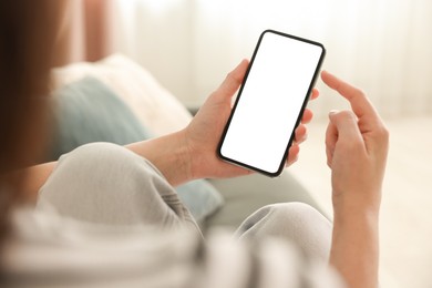Photo of Woman using modern smartphone on sofa at home, closeup