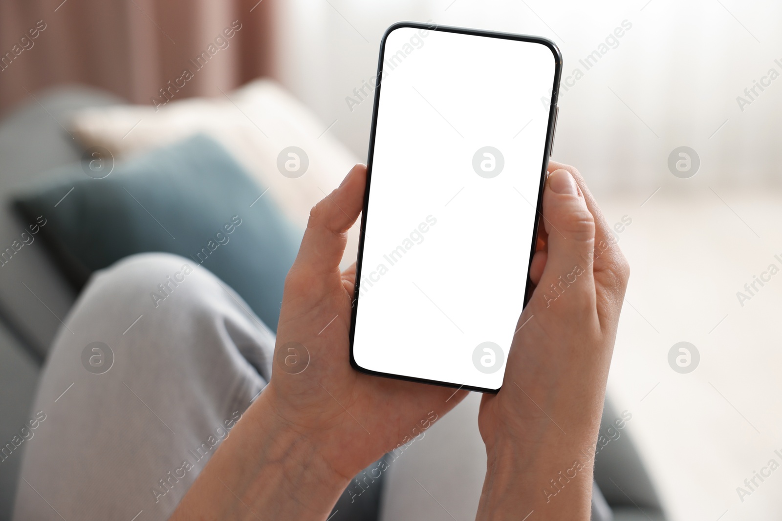 Woman using modern smartphone on sofa at home, closeup Photo of Woman using modern smartphone on sofa at home, closeup
