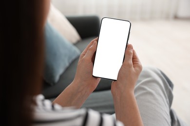 Photo of Woman using modern smartphone on sofa at home, closeup
