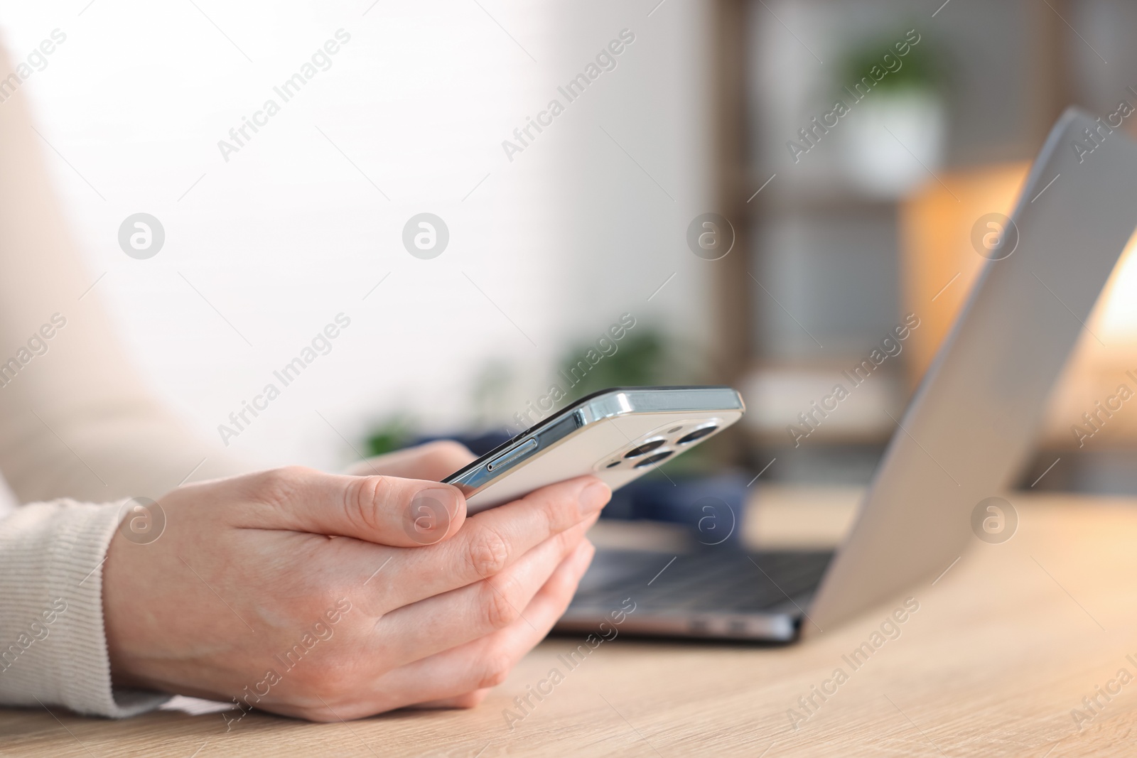 Woman using modern smartphone at wooden table indoors, closeup Photo of Woman using modern smartphone at wooden table indoors, closeup