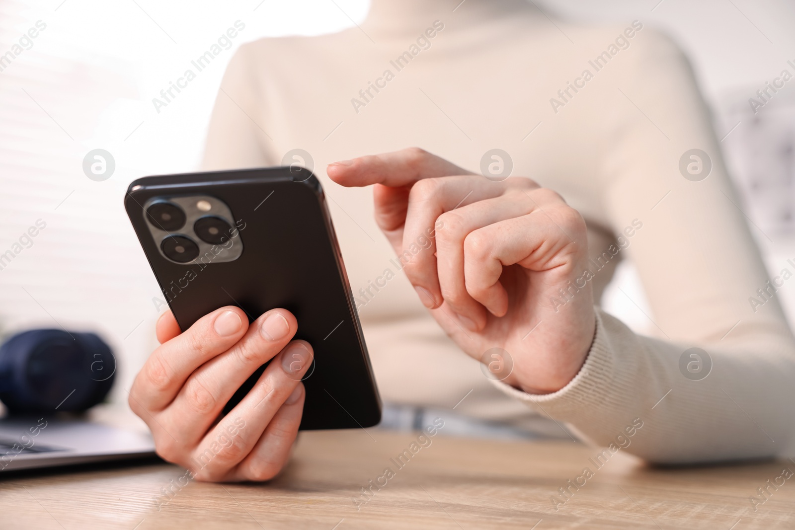 Woman using modern smartphone at wooden table indoors, closeup Photo of Woman using modern smartphone at wooden table indoors, closeup