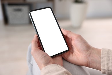 Photo of Woman using modern smartphone at home, closeup