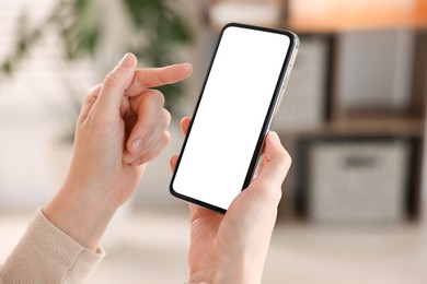 Photo of Woman using modern smartphone at home, closeup