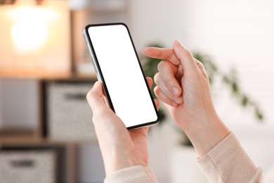 Photo of Woman using modern smartphone at home, closeup