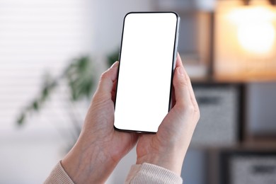 Photo of Woman using modern smartphone at home, closeup