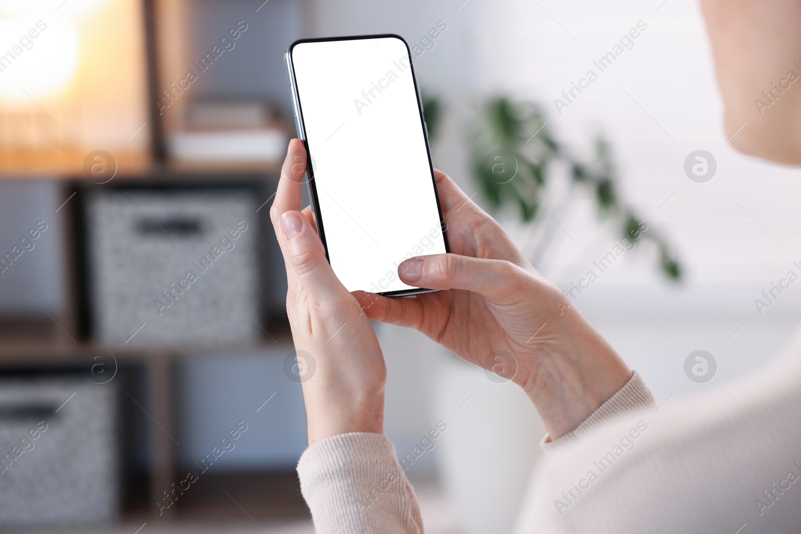 Woman using modern smartphone at home, closeup. Space for text Photo of Woman using modern smartphone at home, closeup. Space for text