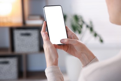 Photo of Woman using modern smartphone at home, closeup. Space for text
