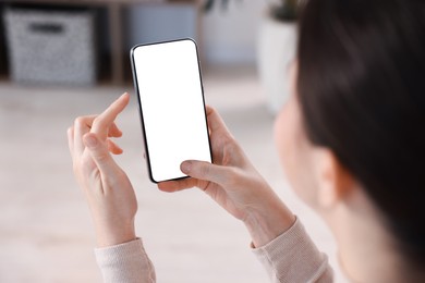 Photo of Woman using modern smartphone at home, closeup