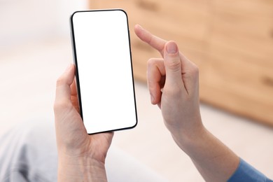 Photo of Woman using modern smartphone at home, closeup