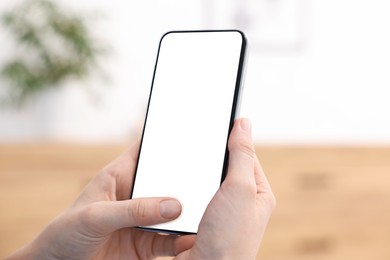 Photo of Woman using modern smartphone at home, closeup