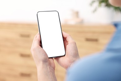 Photo of Woman using modern smartphone at home, closeup