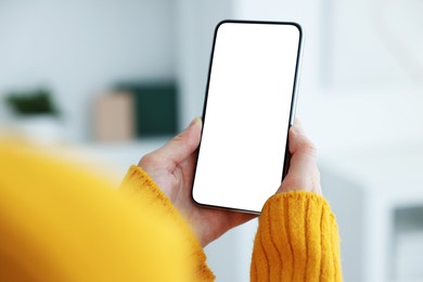 Photo of Woman using modern smartphone at home, closeup