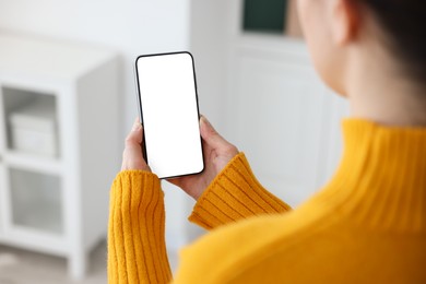 Photo of Woman using modern smartphone at home, closeup