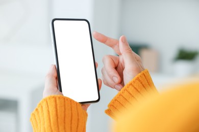 Photo of Woman using modern smartphone at home, closeup