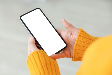 Photo of Woman using modern smartphone at home, closeup