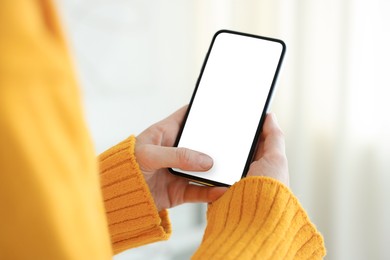 Photo of Woman using modern smartphone at home, closeup