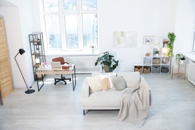 Photo of Comfortable sofa and desk in room, above view