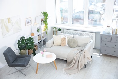 Photo of Comfortable sofa with coffee table and armchair in room, above view