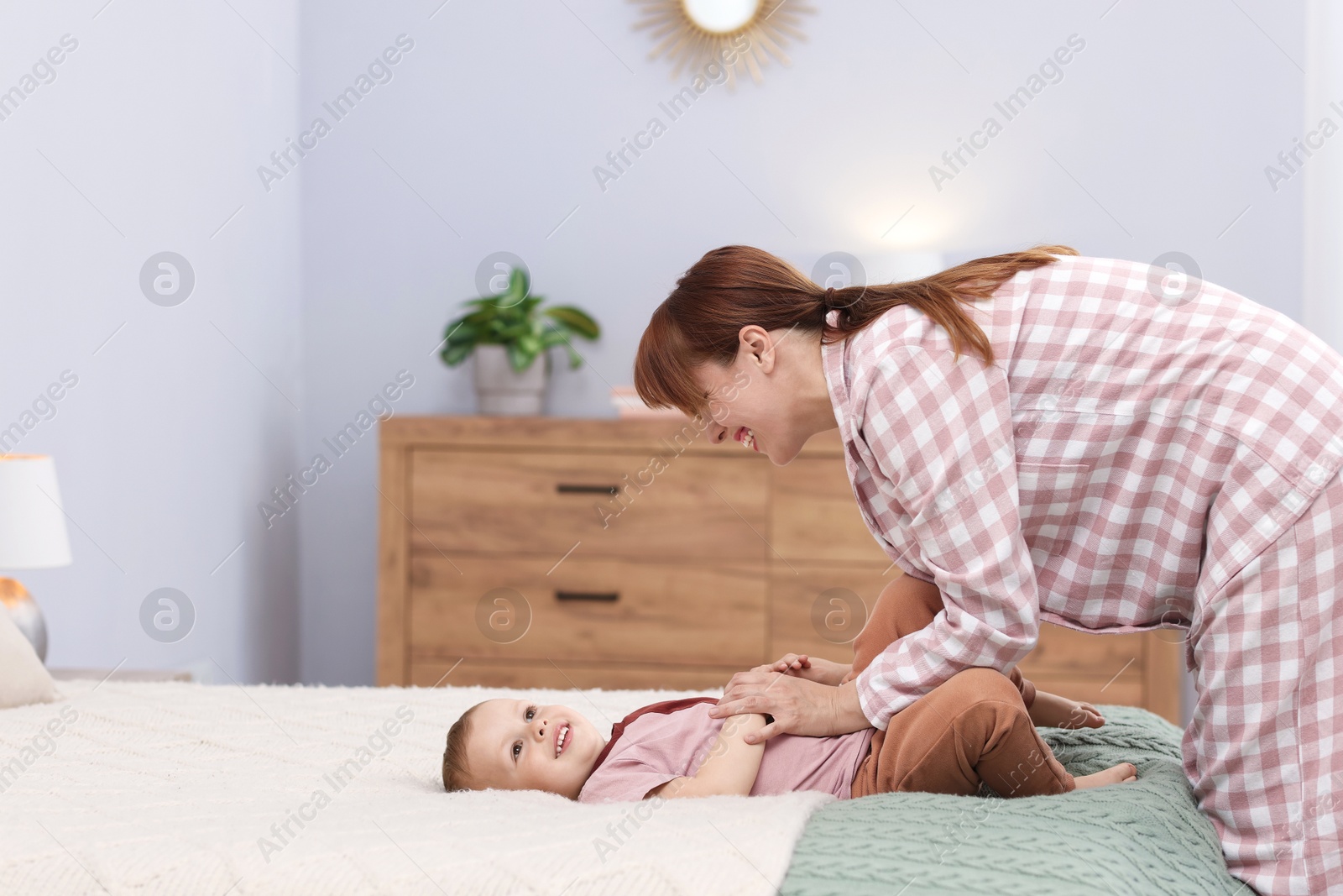 Happy mother spending time together with her son on bed at home Photo of Happy mother spending time together with her son on bed at home