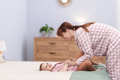 Photo of Happy mother spending time together with her son on bed at home