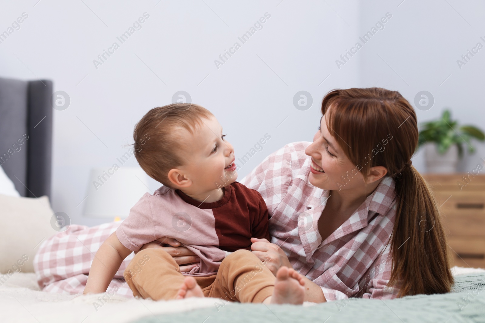 Happy mother spending time together with her son on bed at home Photo of Happy mother spending time together with her son on bed at home