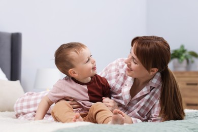 Photo of Happy mother spending time together with her son on bed at home