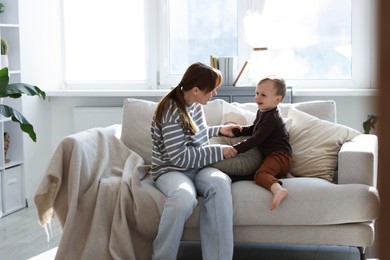 Photo of Mother spending time together with her son on sofa at home
