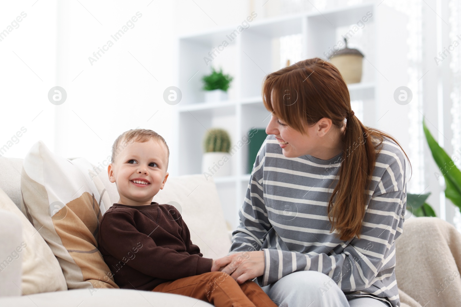 Happy mother spending time together with her son on sofa at home Photo of Happy mother spending time together with her son on sofa at home