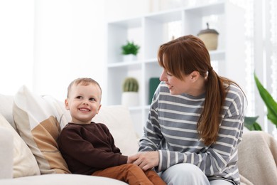 Photo of Happy mother spending time together with her son on sofa at home