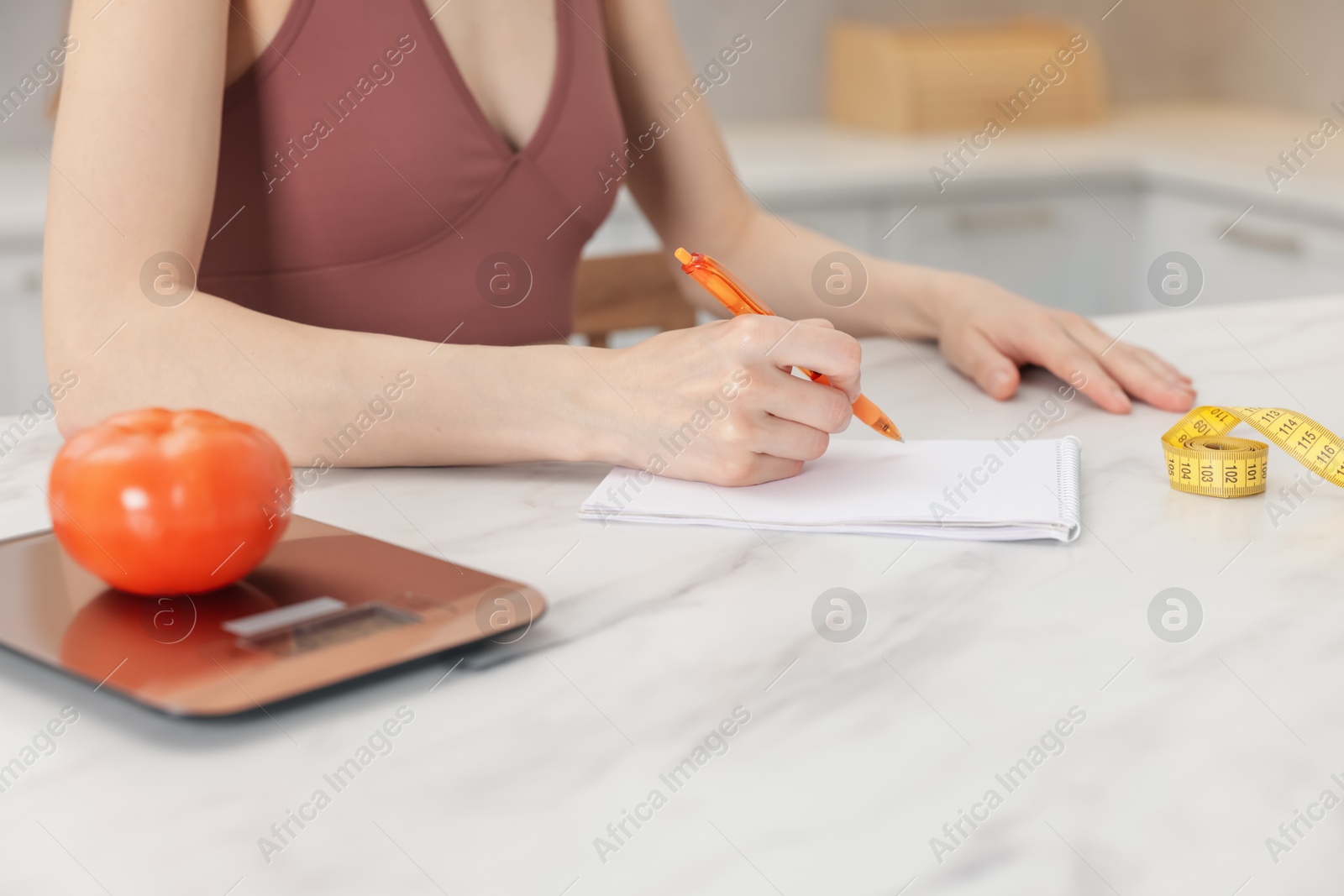 Woman developing diet plan at white marble table indoors, closeup Photo of Woman developing diet plan at white marble table indoors, closeup