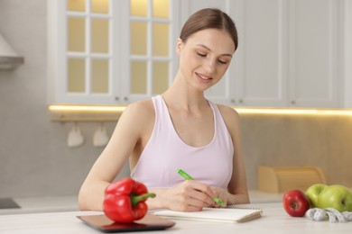 Photo of Woman developing diet plan at white table indoors